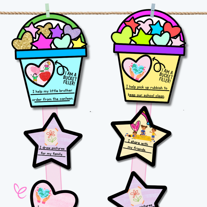 A detailed close-up of a blue 'Bucket Filler' craft displaying a heart with two illustrated children. The text reads, 'I help my little brother order from the canteen.' Glittery hearts and stars decorate the bucket, with kindness-themed messages on attached stars.