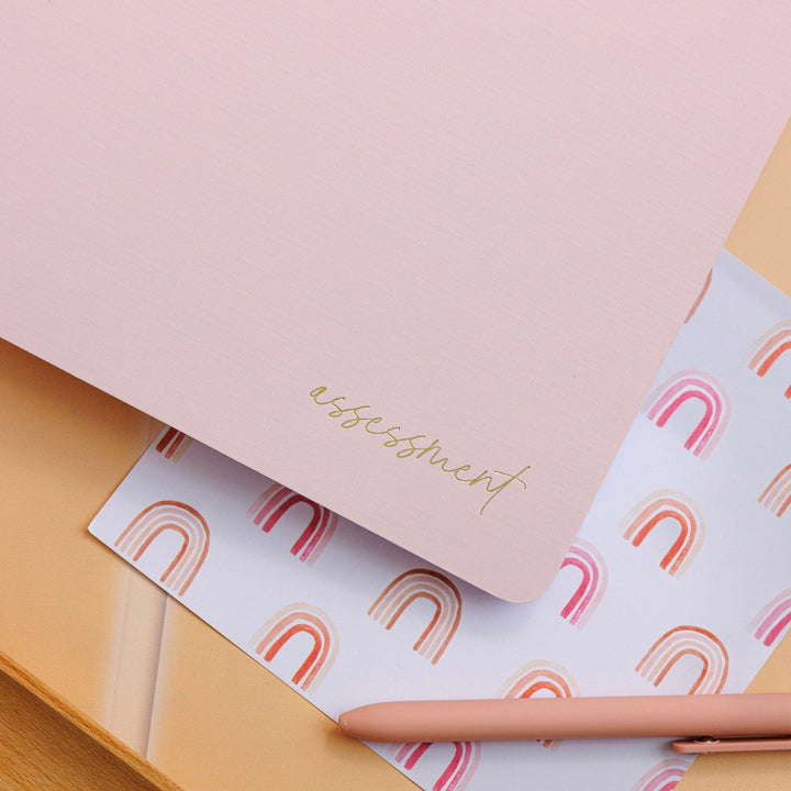 Blush assessment journal placed on a decorative surface, showcasing its elegant design and refined details.