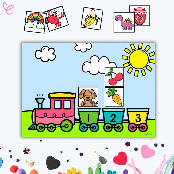 Brightly coloured train graphic with carriages numbered 1 to 4, set against a sunny background with clouds and a green field. Displayed amongst other decorative craft items.