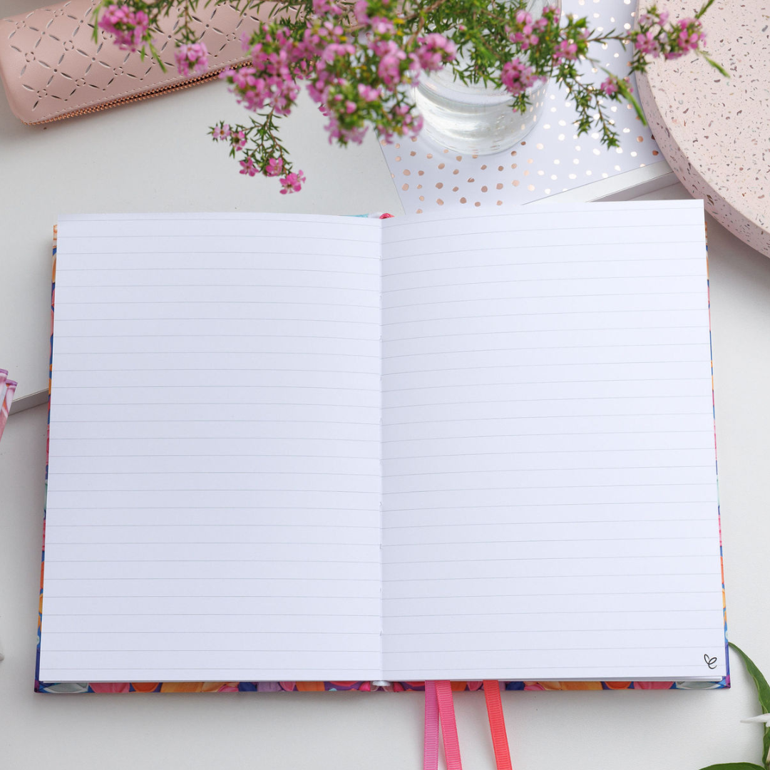 Top-down view of the Awakening A5 Notepad lying open on a desk, showing two lined pages with ample space for notes.