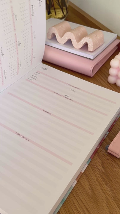 Woman showcasing the neutral internal pages of the 2025 Classic Weekly Teacher Planner 'Love Vibes', highlighting its layout and features.