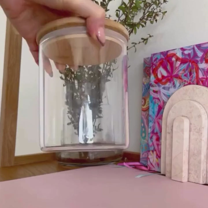 Woman demonstrating how to use digital printable gift tags by filling a jar with teacher items and attaching the gift tag to the jar.