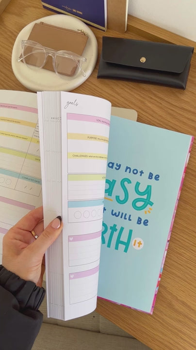 Woman showcasing the bright internal pages of the 2025 Classic Weekly Teacher Planner 'Retro Flowers', highlighting its layout and features.